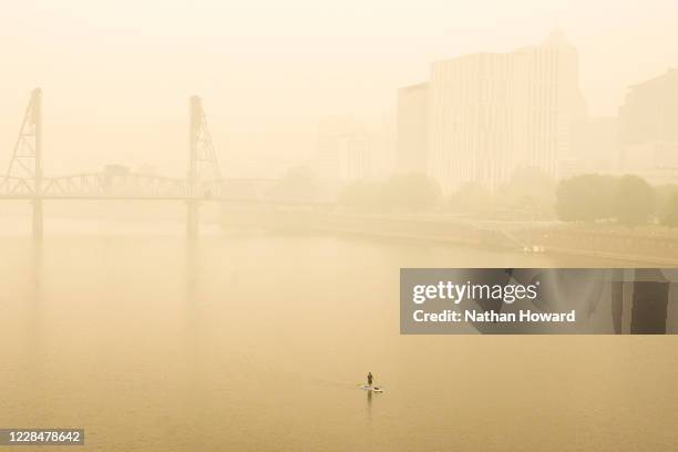 Paddle boarder travels along the Willamette River despite heavy smoke on September 12, 2020 in Portland, Oregon. Multiple wildfires grew by hundreds...