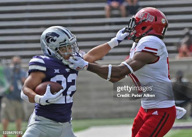 Running back Deuce Vaughn of the Kansas State Wildcats runs up field against pressure from defensive back Elery Alexander of the Arkansas State Red...