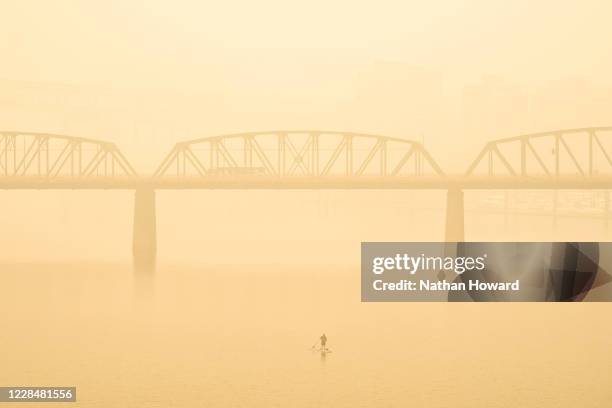 Paddle boarder travels along the Willamette River despite heavy smoke on September 12, 2020 in Portland, Oregon. Multiple wildfires grew by hundreds...