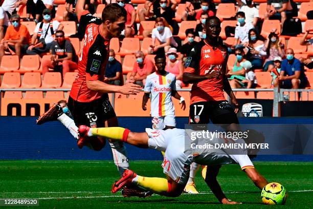 Lorients French defender Vincent Le Goff tackles Lens French forward Corentin Jean during the French Ligue 1 football match between Lorient and Lens,...