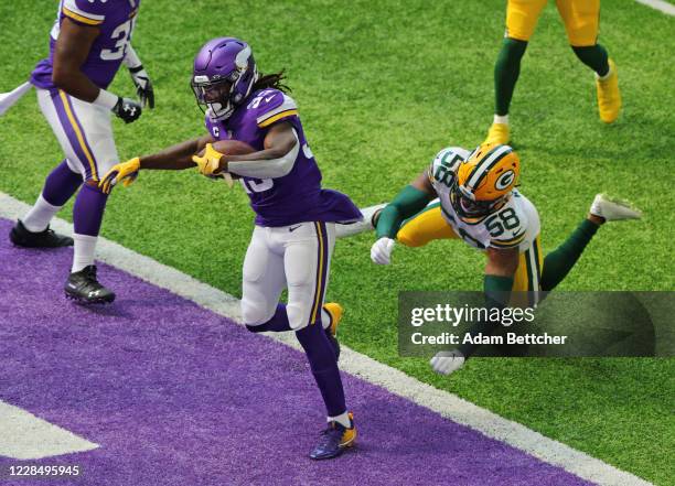 Dalvin Cook of the Minnesota Vikings scores a touchdown against Christian Kirksey of the Green Bay Packers in the first quarter at U.S. Bank Stadium...