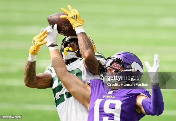 Jaire Alexander of the Green Bay Packers intercepts the ball against Adam Thielen of the Minnesota Vikings during the second quarter of the game at...