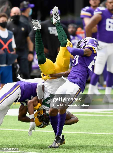 Anthony Harris and Mike Hughes of the Minnesota Vikings tackle Davante Adams of the Green Bay Packers during the second quarter of the game at U.S....