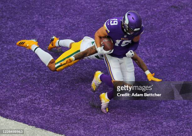 Adam Thielen of the Minnesota Vikings pulls in a pass for a touchdown against coverage by Jaire Alexander of the Green Bay Packers in the fourth...