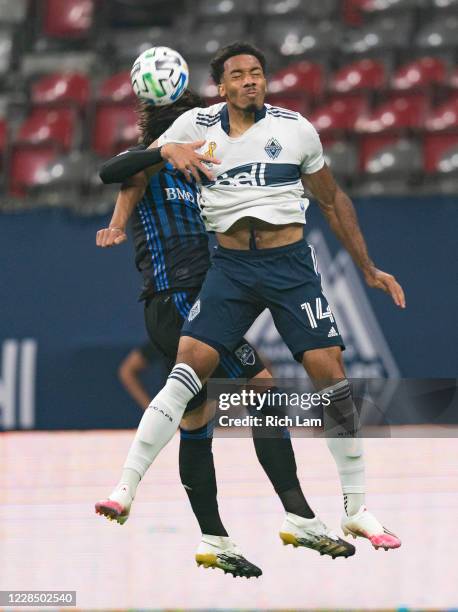 Thelonius Bair of the Vancouver Whitecaps goes up against Luis Binks of the Montreal Impact for a header during MLS soccer action at BC Place on...