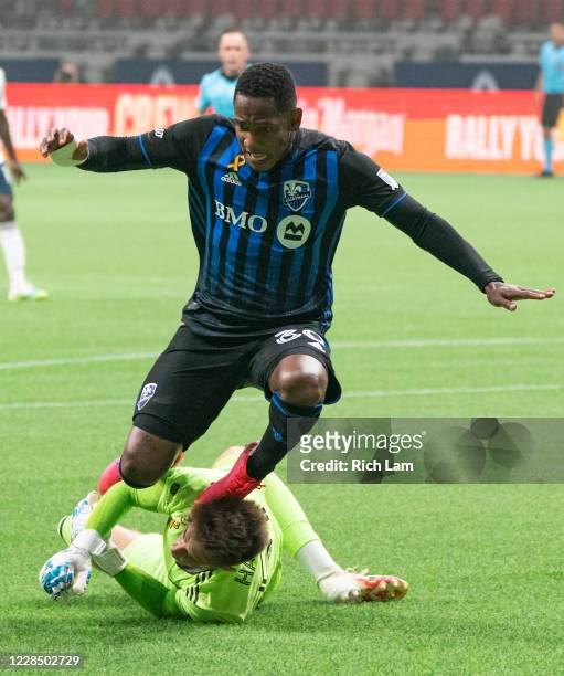 Goalkeeper Thomas Hasal of the Vancouver Whitecaps knocks down Romell Quioto of the Montreal Impact in the penalty area during MLS soccer action at...