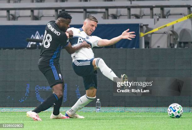 Orji Okwonkwo of the Montreal Impact grabs David Milinkovic of the Vancouver Whitecaps while battling for the ball during MLS soccer action at BC...