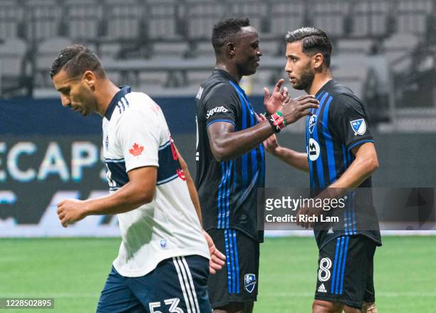Saphir Taïder of the Montreal Impact is congratulated by teammate Victor Wanyama after scoring a goal on a penalty kick as Ali Adnan of the Vancouver...