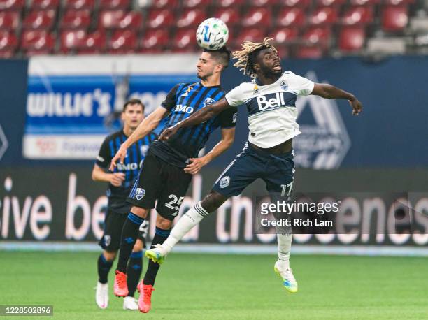Leonard Owusu of the Vancouver Whitecaps looses a header to Emanuel Maciel of the Montreal Impact during MLS soccer action at BC Place on September...