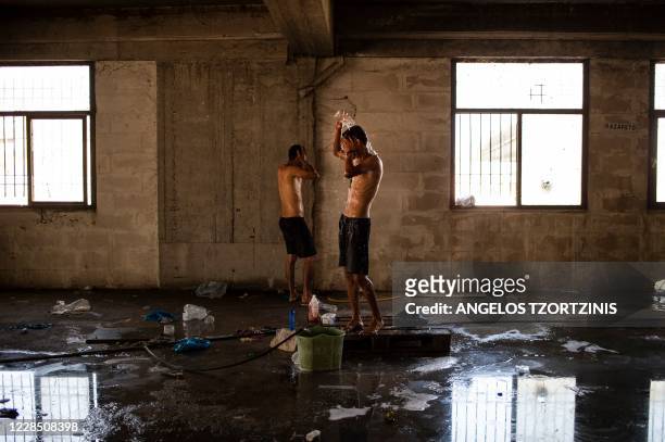 Migrants clean themselves inside an abandoned building near the Kara Tepe camp on the island of Lesbos on September 13, 2020. - Over 11,000 people --...