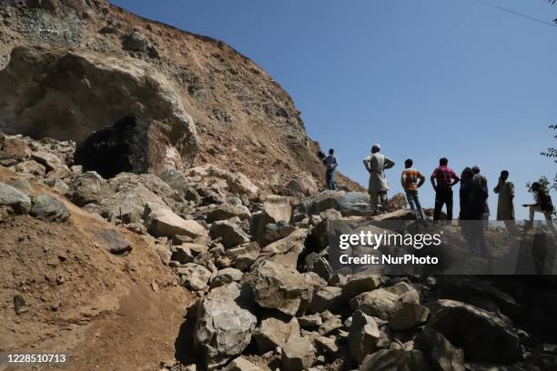 Villagers look towards the hill after the landslides, created panic in Hardi Shiva village of Sopore, District Baramulla, Jammu and Kashmir, India on...