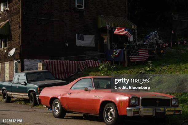 American flags stand on display outside a home in Braddock, Pennsylvania, U.S., on Saturday, Sept. 12, 2020. A narrow win in Pennsylvania helped...