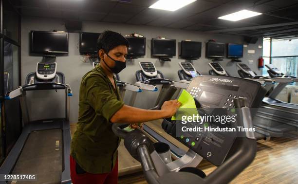 Staff member cleans equipment inside Anytime Fitness gym after it reopened for the first time since the nationwide lockdown was imposed to curb the...