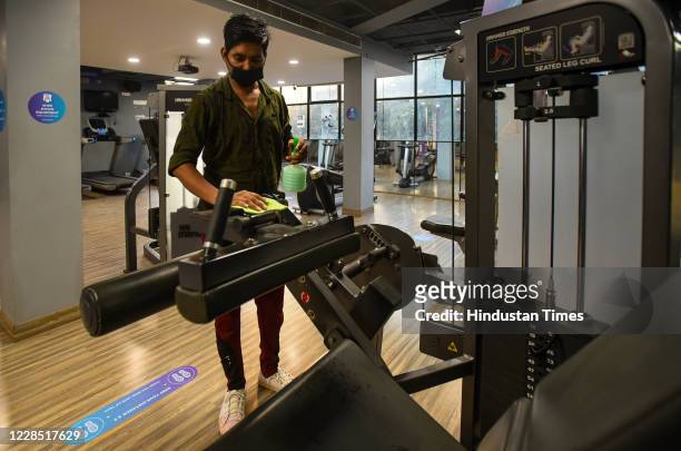 Staff member cleans equipment inside Anytime Fitness gym after it reopened for the first time since the nationwide lockdown was imposed to curb the...