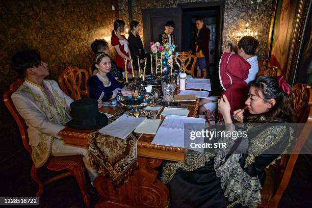 This photo taken on August 13, 2020 shows players preparing to take part in the live action role-play murder mystery game "The Haunted Mansion" at a...