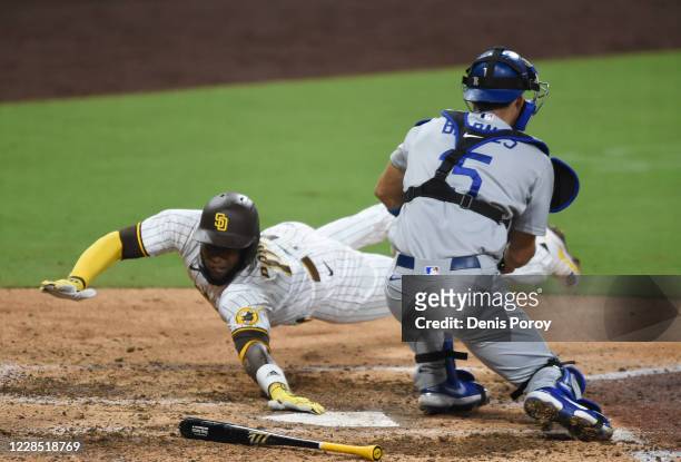 Jurickson Profar of the San Diego Padres scores ahead of the tag of Austin Barnes of the Los Angeles Dodgers during the seventh inning of a baseball...