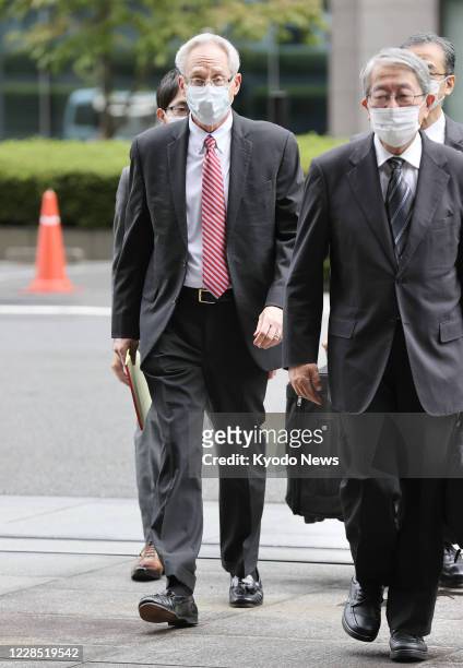Former Nissan Motor Co. Executive Greg Kelly, who was a close aide of Carlos Ghosn, enters the Tokyo District Court at the start of his trial on...