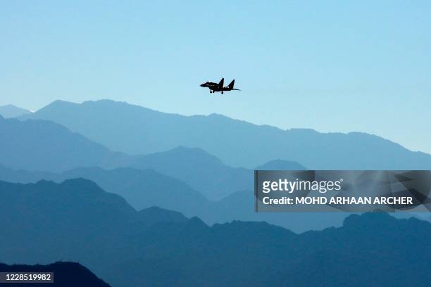 An Indian Air Force fighter jet flies over a mountain range in Leh, the joint capital of the union territory of Ladakh bordering China, on September...