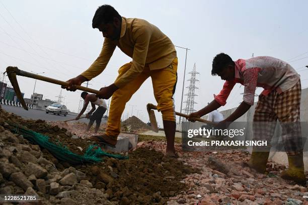 Labourers work on Meerut Expressway being constructed by the National Highways Authority of India , in Ghaziabad on September 15, 2020. -...