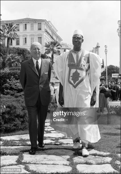 Le président malien Moussa Traore marche en compagnie de Jacques Foccart, secrétaire général de l'Elysée pour les Affaires africaines et malgaches,...