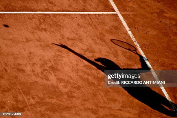 The shadow of Guido Pella of Argentina is cast on the court as he serves to Denis Shapovalov of Canada on day two of the Italian Open at Foro Italico...