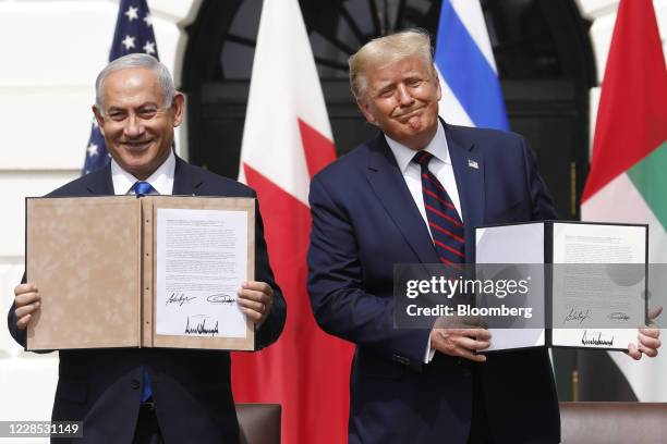 President Donald Trump and Benjamin Netanyahu, Israel's prime minister, left, hold signed documents during an Abraham Accords signing ceremony event...