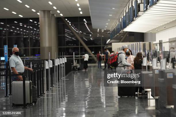 Travelers check in at the Delta Air Lines counter on opening day of the Salt Lake City International Airport in Salt Lake City, Utah, U.S., on...