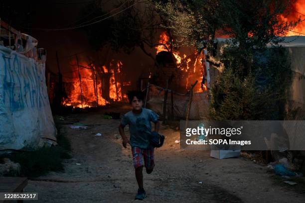 Child flees the Moria refugee camp after fires completely destroyed the camp on Wednesday. Thousands of people have been forced to flee their homes...