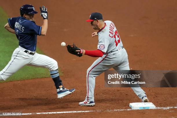 Asdrubal Cabrera of the Washington Nationals cannot hold on to a throw as Willy Adames of the Tampa Bay Rays is safe at first base in the fourth...