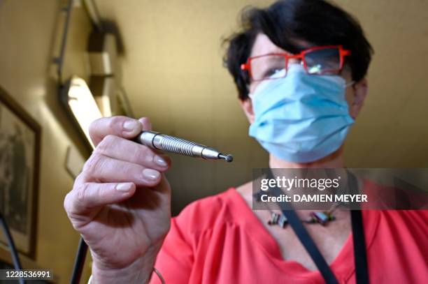 In this photograph taken on September 15 Annick Le Mescam, president of the Hospital heritage conservatory poses with a foot operated dental drill at...