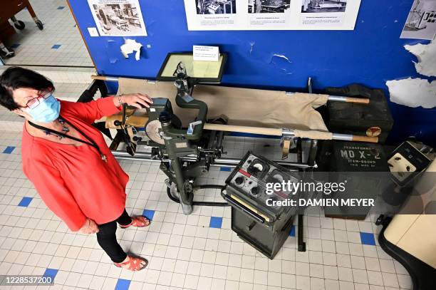 In this photograph taken on September 15 Annick Le Mescam, president of the Hospital heritage conservatory poses with a US army X-ray machine at The...