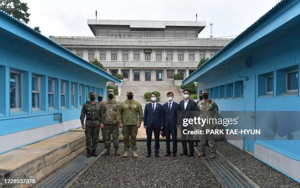 South Korean Unification Minister Lee In-young poses with military officers in front of the military demarcation line during a visit to the south...