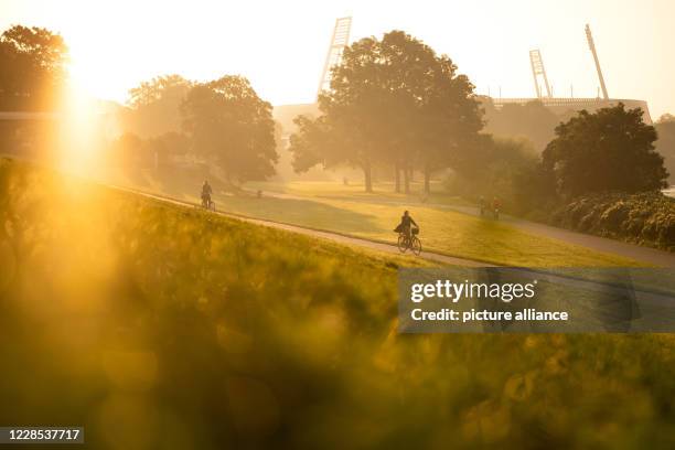 September 2020, Bremen: Cyclists ride in the early morning near the Weser stadium. The time of the ghost games is over in the Weserstadion for the...
