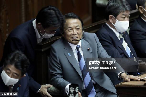 Taro Aso, Japan's deputy prime minister and finance minister, center, reacts as he attends an extraordinary session at the lower house of parliament...