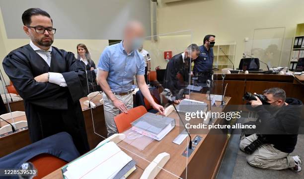 September 2020, Bavaria, Munich: The defendant stands between his lawyers Yuri Goldstein and Alexander Dann at the beginning of the trial against him...