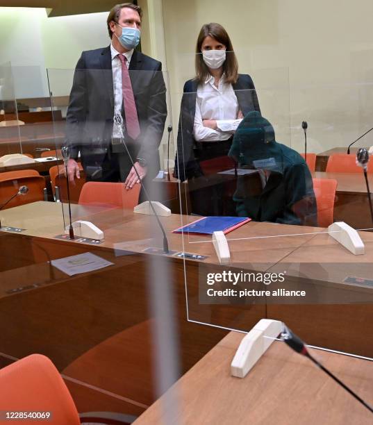 September 2020, Bavaria, Munich: A co-defendant is sitting between her lawyers Eva Krötz and Vincent Burgert at the start of the trial against her on...