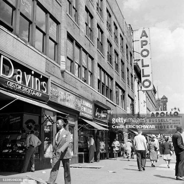 People pass by shops on the 125th Street in 1946, near the Apollo Theatre, the famous jazz club in Harlem, Manhattan, New York City.
