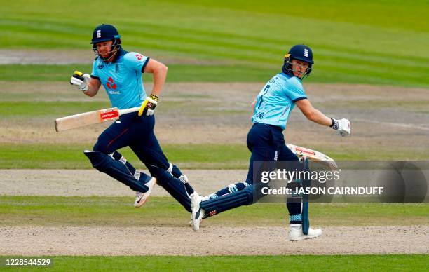 England's batsmen Jonny Bairstow and Sam Billings pass each other as they run down the wicket to score runs during the one-day international cricket...