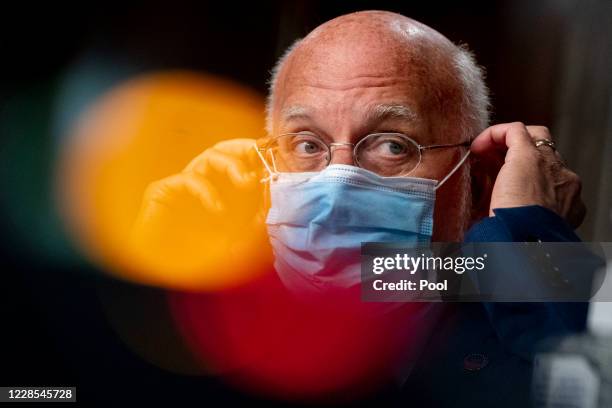 Centers for Disease Control and Prevention Director Dr. Robert Redfield puts his mask on after speaking at a hearing of the Senate Appropriations...