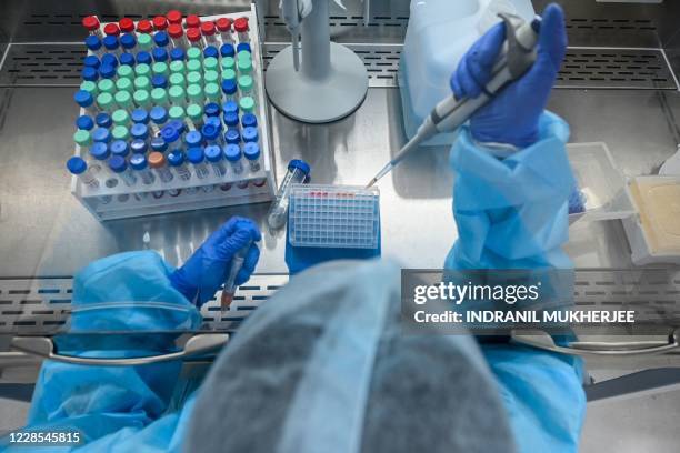 Laboratory staff wearing Personal Protective Equipments conducts a procedure from samples collected for Covid-19 coronavirus testing as part of...