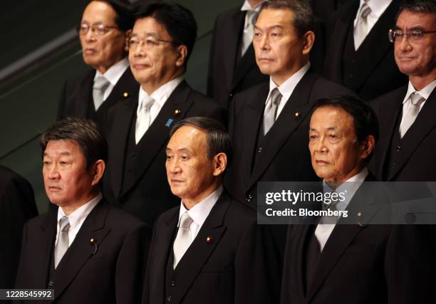 Yoshihide Suga, Japan's prime minister, front row center, poses for a group photograph with his new cabinet members at his official residence in...