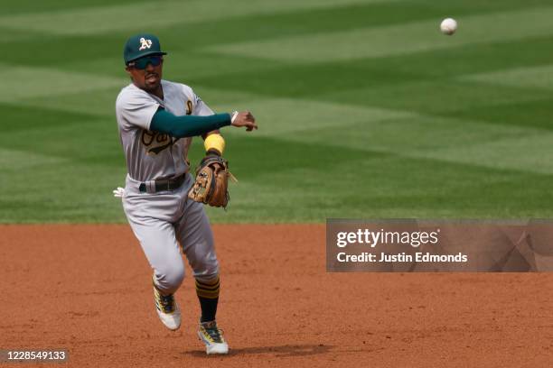 Tony Kemp of the Oakland Athletics throws to first base for an out during the second inning against the Colorado Rockies at Coors Field on September...