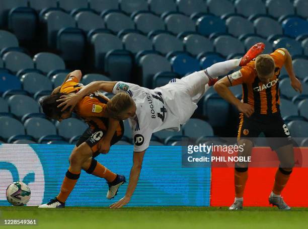 Leeds United's Polish midfielder Mateusz Bogusz clashes with Hull City's English midfielder George Honeyman and Hull City's English midfielder Daniel...