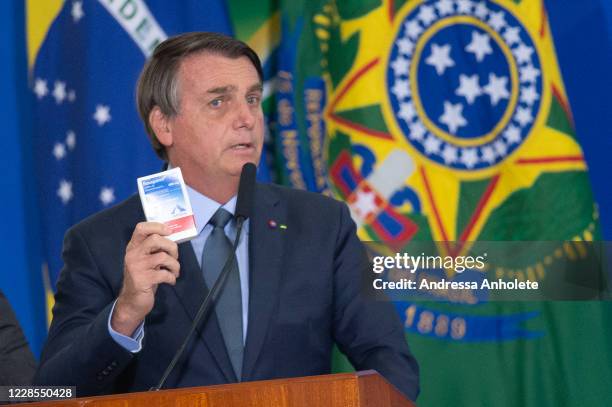 President of Brazil Jair Bolsonaro shows a box of chloroquine medicine during the ceremony in which Eduardo Pazuello takes office as Minister...