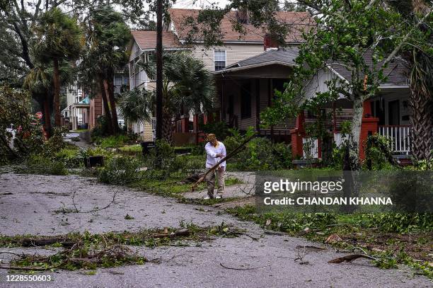 Mark Robinson removes the branch of a tree after Hurricane Sally outside this home in Pensacola, Florida on September 16, 2020. - Hurricane Sally...