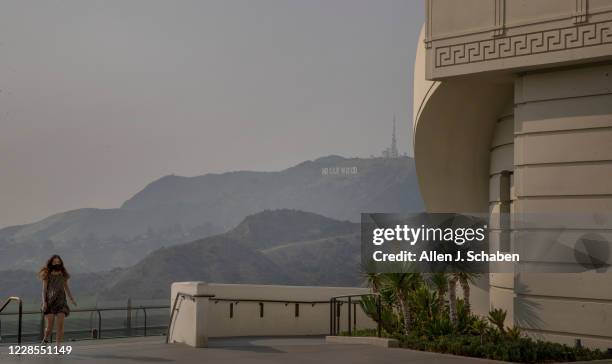 Visitor walks around the Griffith Observatory with a smokey/smoggy view of the Los Angeles skyline and Hollywood sign Monday, Sept. 14, 2020 in Los...