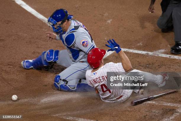 Scott Kingery of the Philadelphia Phillies slides in safely to score a run past Wilson Ramos of the New York Mets in the bottom of the second inning...