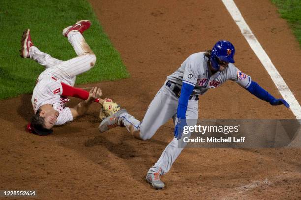 Scott Kingery of the Philadelphia Phillies tags out Jeff McNeil of the New York Mets at home in the top of the ninth inning at Citizens Bank Park on...