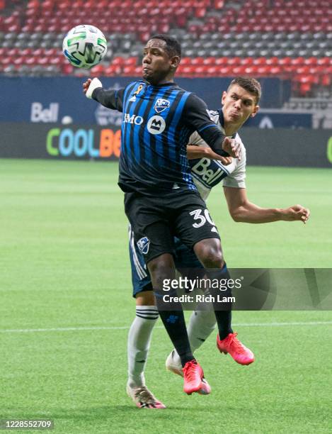 Romell Quioto of the Montreal Impact receives a pass off his chest while defend against by Ranko Veselinovic of the Vancouver Whitecaps during MLS...