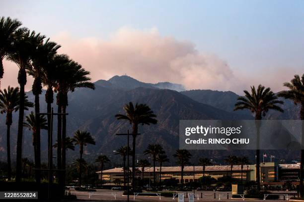 Smoke rises from the Bobcat Fire burning in the San Gabriel mountains above Arcadia, California on September 16, 2020. - California faces more...